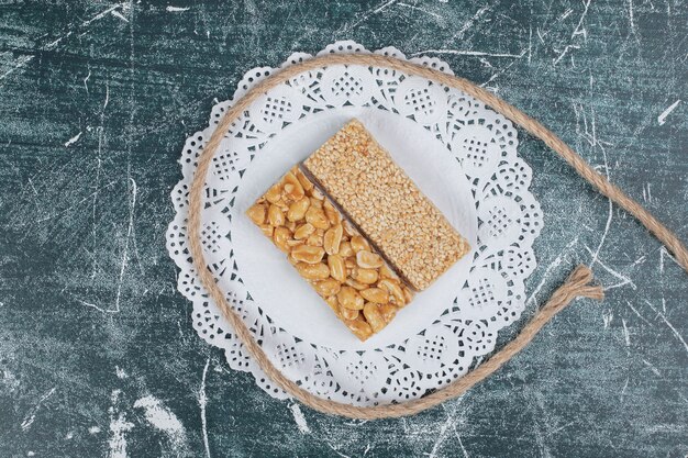 Brittle candies with rope on marble wall.