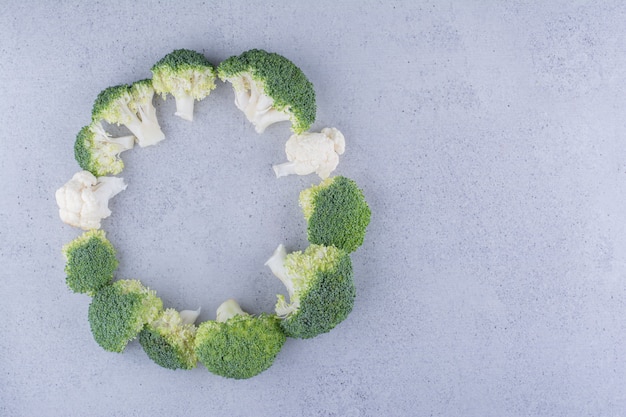 Free Photo broccoli arranged in a ring on marble background.