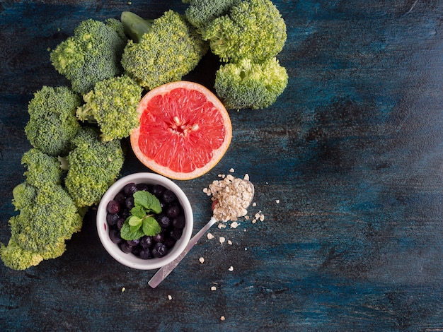 Free photo broccoli with blueberries and grapefruit on table