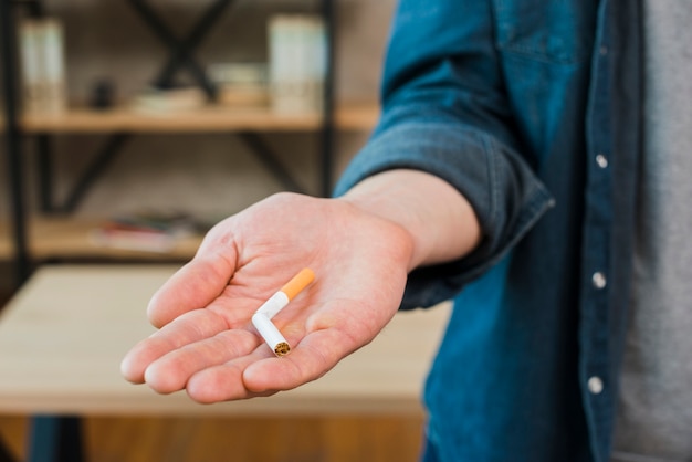 Free photo broken cigarette in man's hand