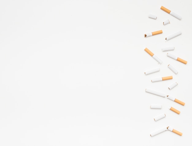 Broken cigarettes arranged on bottom over isolated on white background