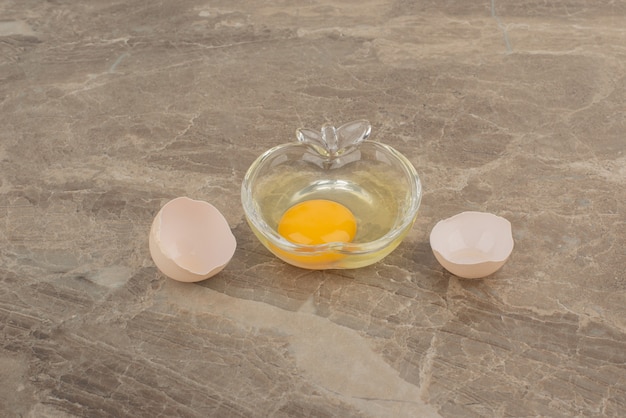 Broken egg on plate on marble table .