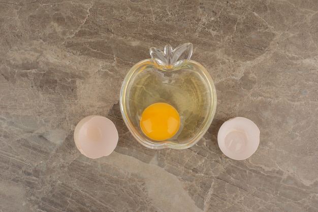 Free photo broken egg on plate on marble table .