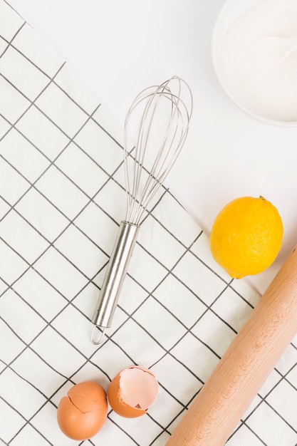 Free photo broken eggshells; lemon; sugar and napkin isolated on white background