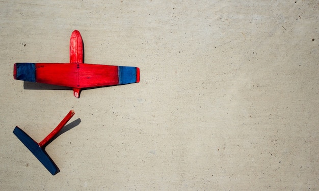 Free photo broken wodden glider lying on cement