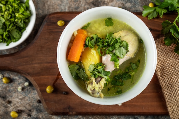 Broth soup with carrot,potato and minced greenery