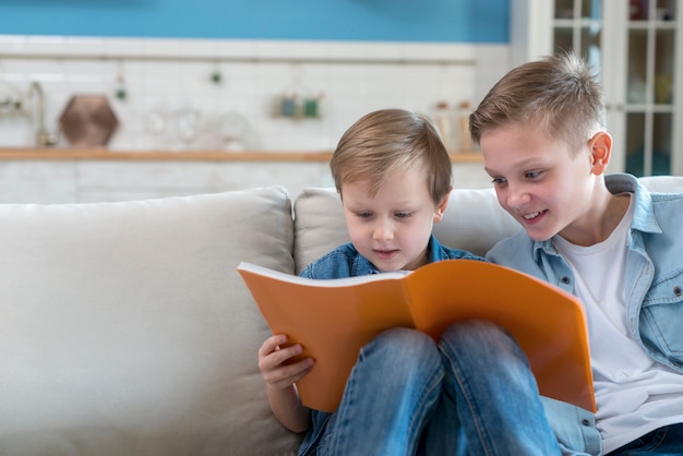 Free photo brothers reading a book together