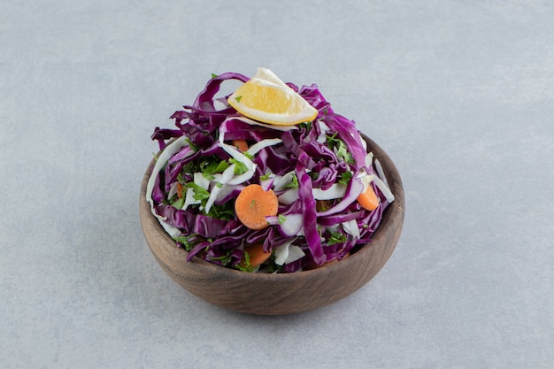 A brown bowl of mixed vegetables , on the marble.