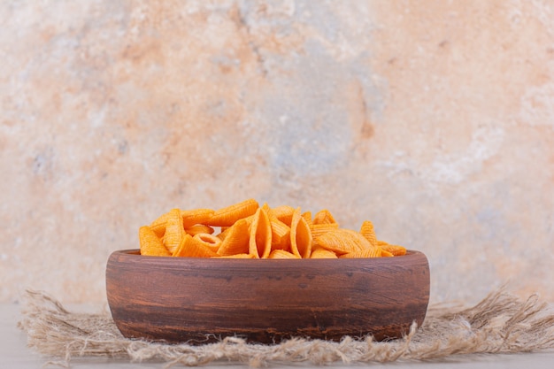 Brown bowl of triangle chips on white background. High quality photo