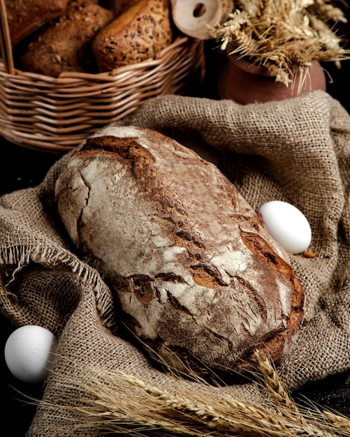 Brown bread loaf served on linen cloth in rustic style