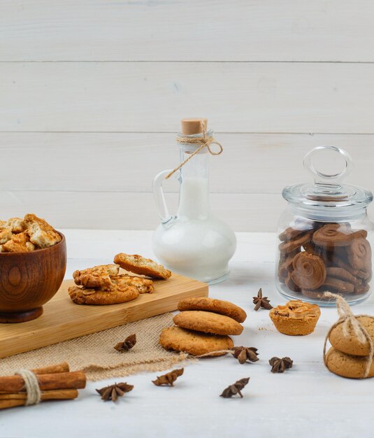 Brown cookies in a glass jar with a jug of milk,cookies and cinnamon