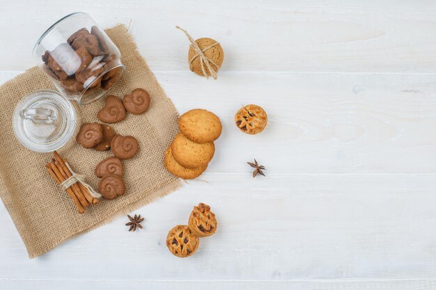 Brown cookies in a jar,cinnamon in a placemat with white cookies