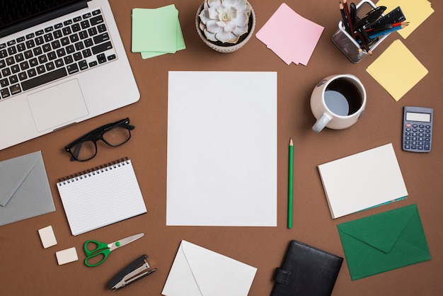 Free Photo brown desktop with coffee cup; laptop and office supplies