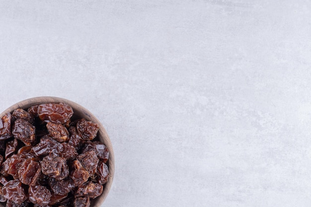 Brown dried cherries inside a dish on concrete background. High quality photo