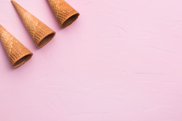 Free photo brown empty ice cream cones on pink background