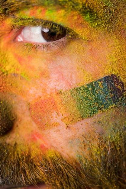 Free photo brown eye of young homosexual man with bright colorful paint