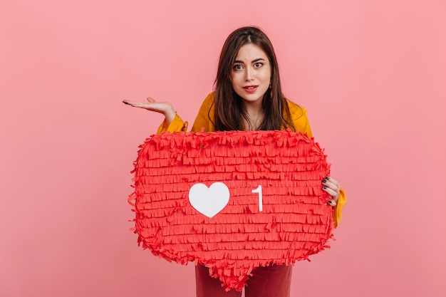 Free Photo brown-eyed woman stares in perplexity, holding "like" sign from social networks.