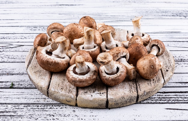 Free photo brown mushrooms in a cutting board high angle view