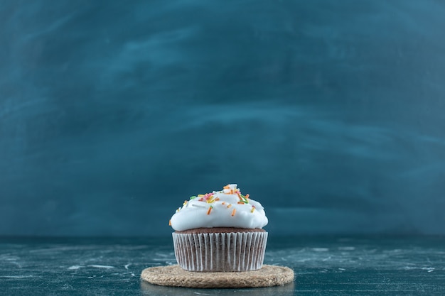 Brownie cakes with cream on a trivet , on the blue background. High quality photo