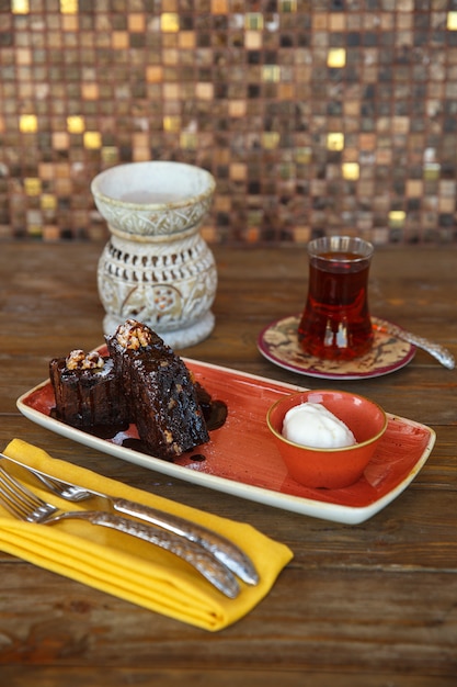 Brownie pieces with vanilla ice cream served with black tea