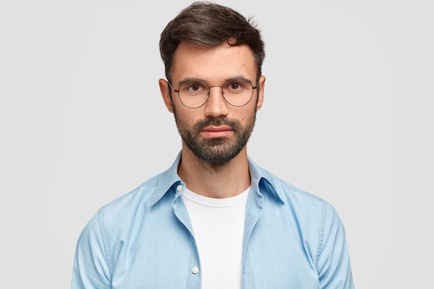 Brunet man wearing round eyeglasses and blue shirt