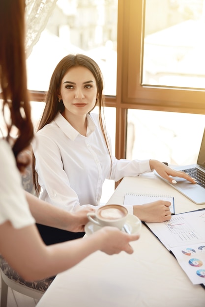 Brunette administrator of a restaurant at her working place is getting a latte