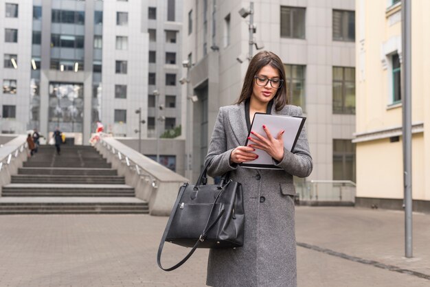 Brunette businesswoman outdoors reading document