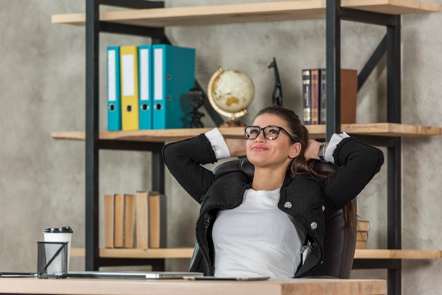 Free Photo brunette businesswoman relaxing at her office