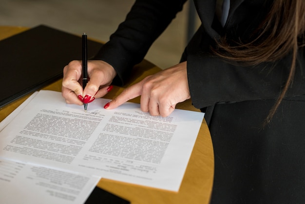 Brunette businesswoman writing on a document