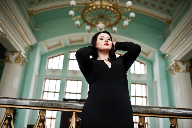 Free photo brunette girl in black dress in railway station indoor