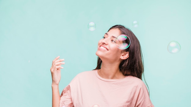 Brunette girl playing with soap bubbles