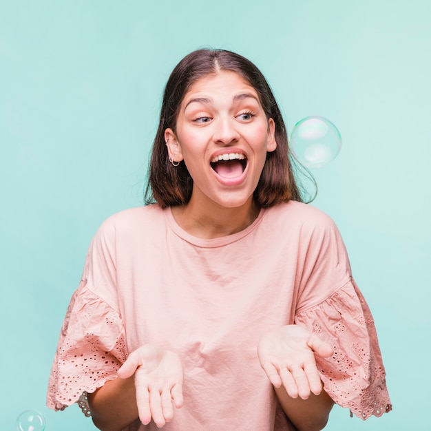 Brunette girl playing with soap bubbles