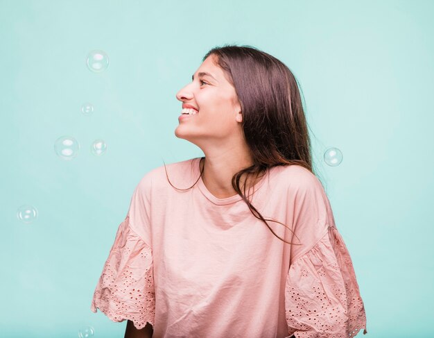 Brunette girl playing with soap bubbles