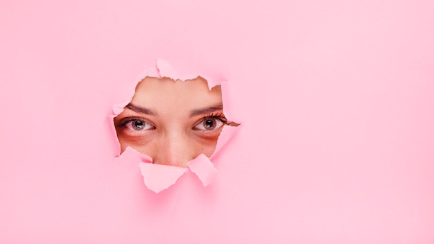 Free photo brunette girl posing through a paper hole