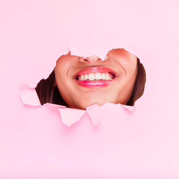 Free Photo brunette girl posing through a paper hole