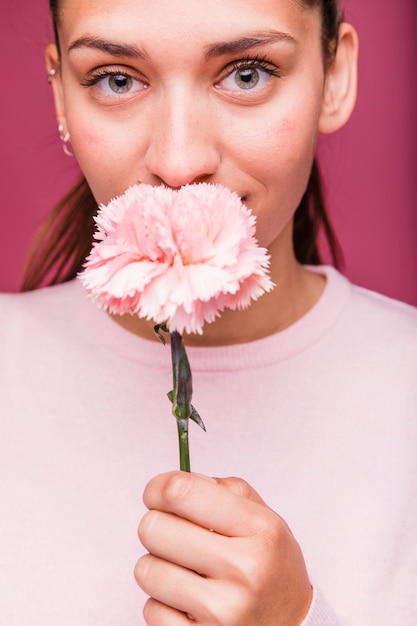 Free photo brunette girl posing with carnation