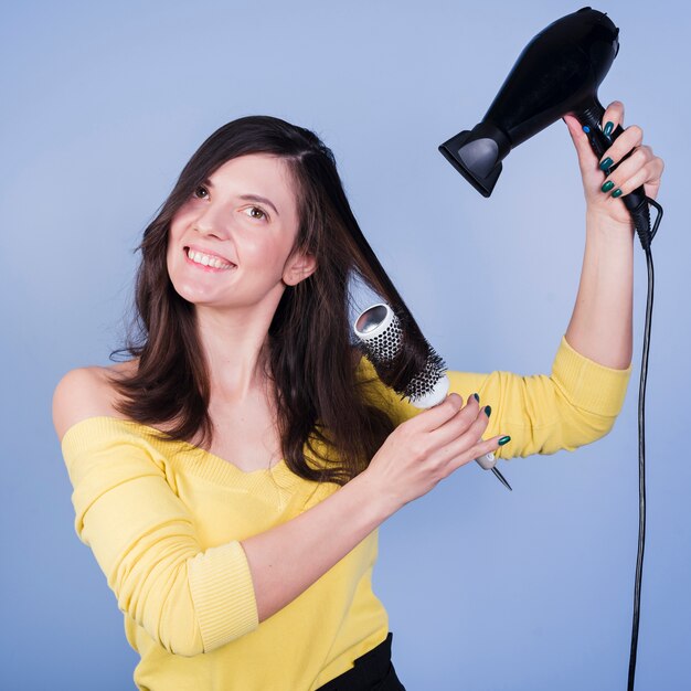 Brunette girl posing with hair dryer