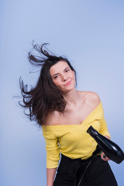 Brunette girl posing with hair dryer