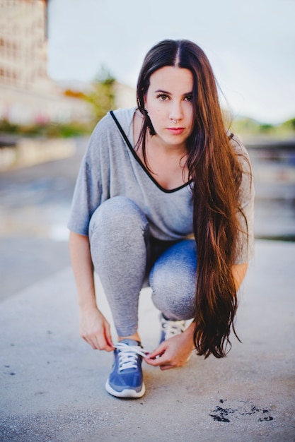 Brunette girl sitting tying up shoes