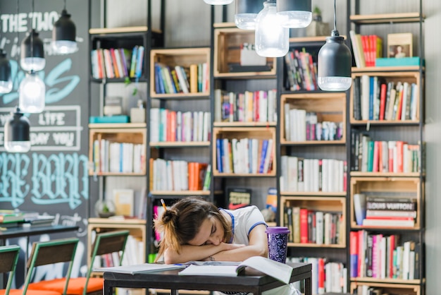 Free photo brunette girl sleeping on table