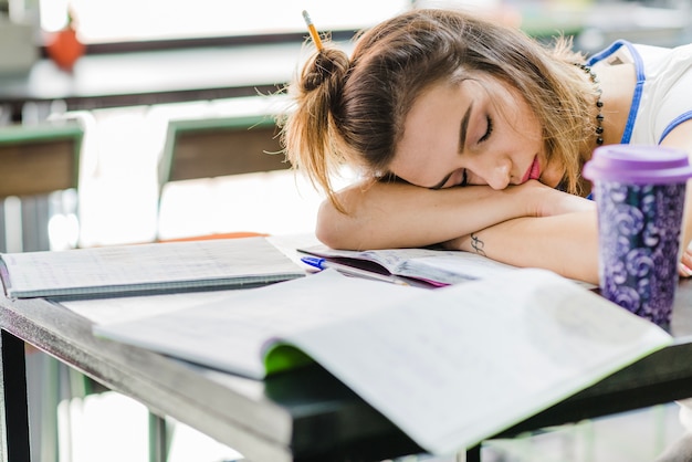 Free photo brunette girl sleeping on table