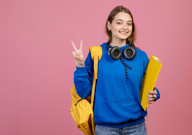 Brunette girl standing smiling showing peace greeting