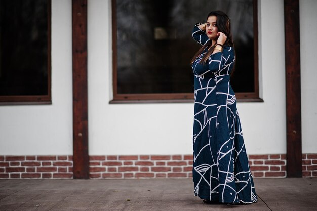 Brunette indian woman in long fashionable dress posed outdoor