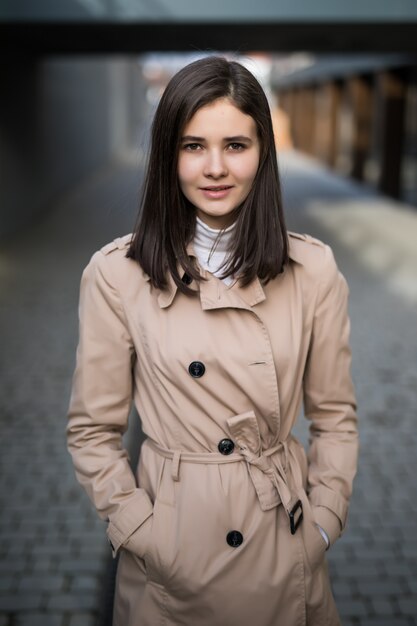 Brunette lady stays in the city in front of big buildings