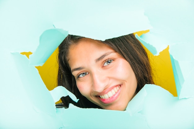 Brunette model posing through paper hole