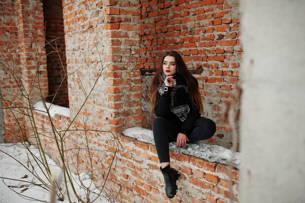 Brunette stylish casual girl in scarf against brick place