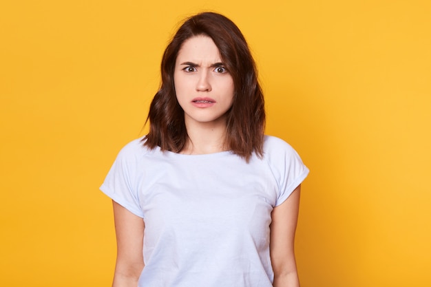 Brunette woman in casual clothes expressing disgust