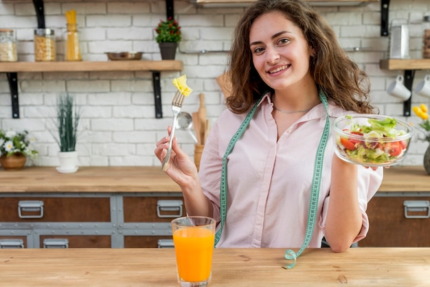 Free photo brunette woman eating a salad