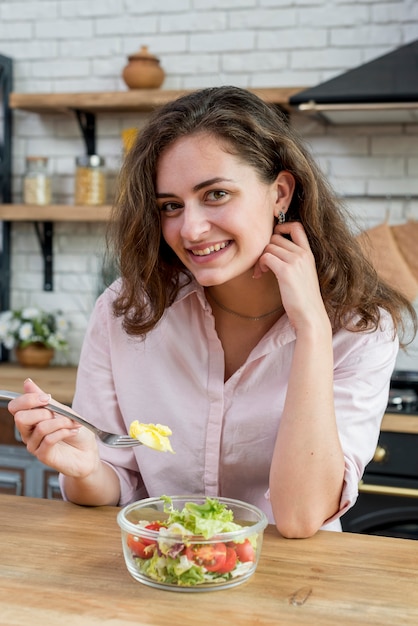 Brunette woman eating a salad