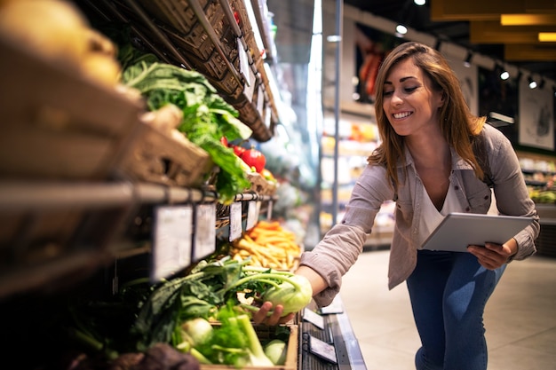 Brunette woman enjoys choosing food at supermarket